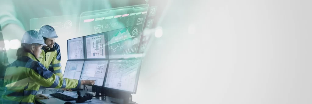 Two industrial engineers using connectivity software on large monitors in an industrial setting to integrate OT and IT systems with Kepware, OPC Router, and Industry 4.0 solutions.