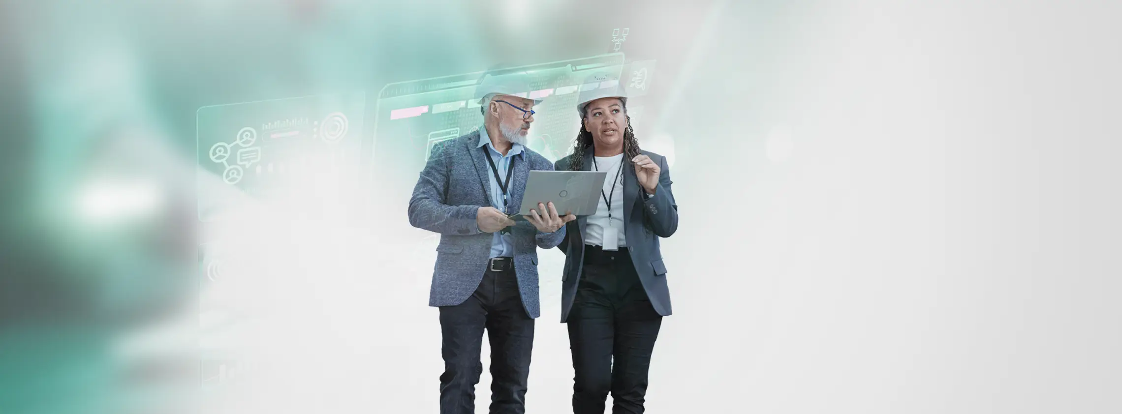 Two executives or decision makers in hard hats walking through an industrial facility, discussing automation software strategies and resources.